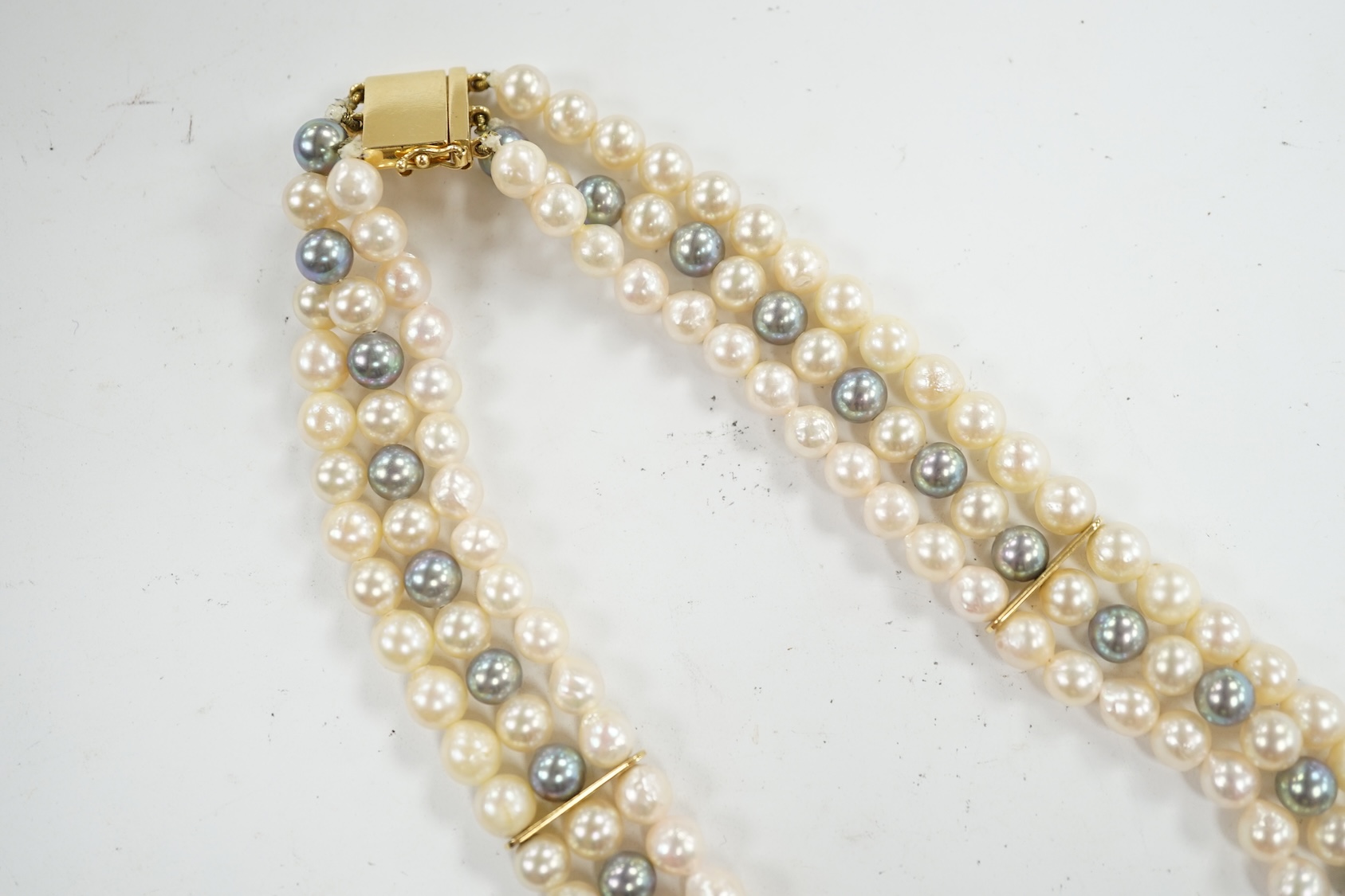 A modern triple strand two colour cultured pearl necklace, with yellow metal clasp and detachable yellow metal baroque pearl, sapphire and diamond cluster set clip, 43cm, gross weight 101.9 grams. Condition - fair to goo